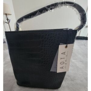 AOTA Elena bucket bag in black croc-embossed vegan leather. 